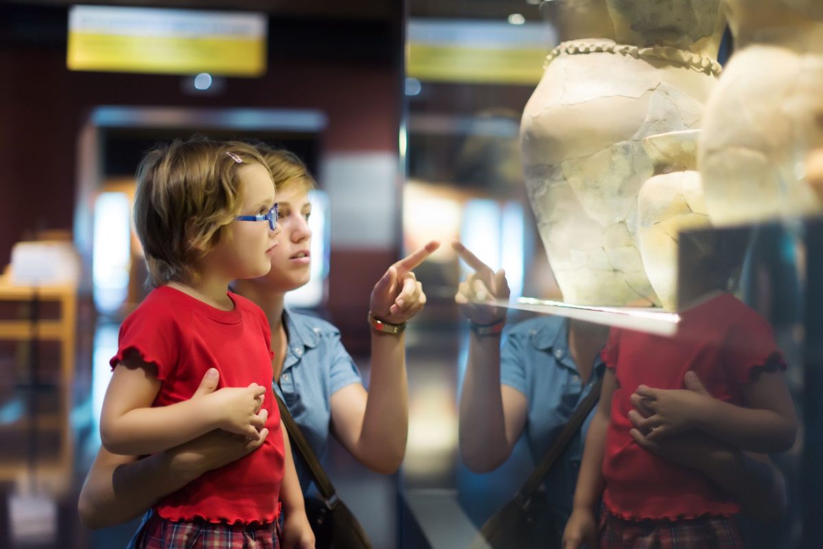 a mother and daughter looking at a museum exhibit